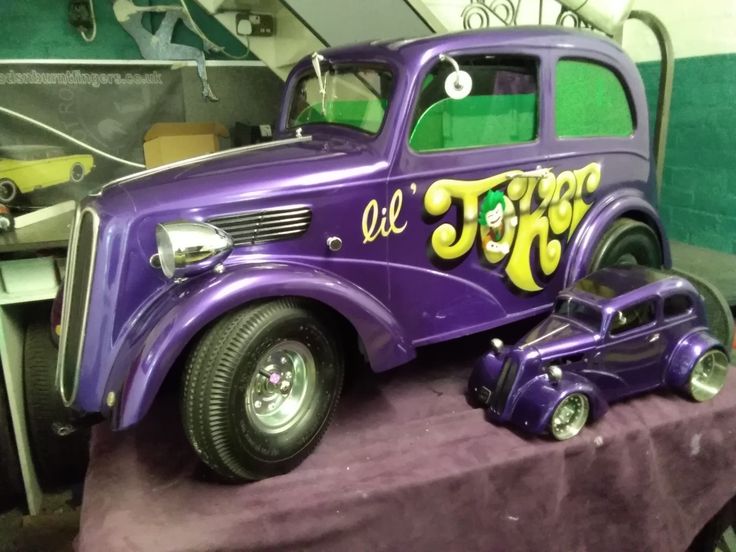 an old purple toy car with graffiti on it