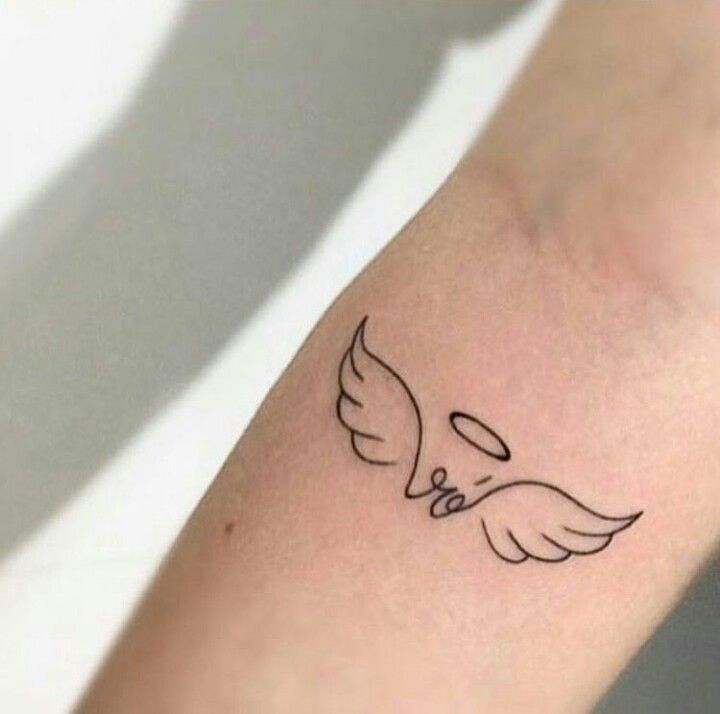 a small tattoo on the arm of a person with an angel wing and two hearts