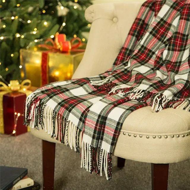 a plaid blanket draped over a chair in front of a christmas tree