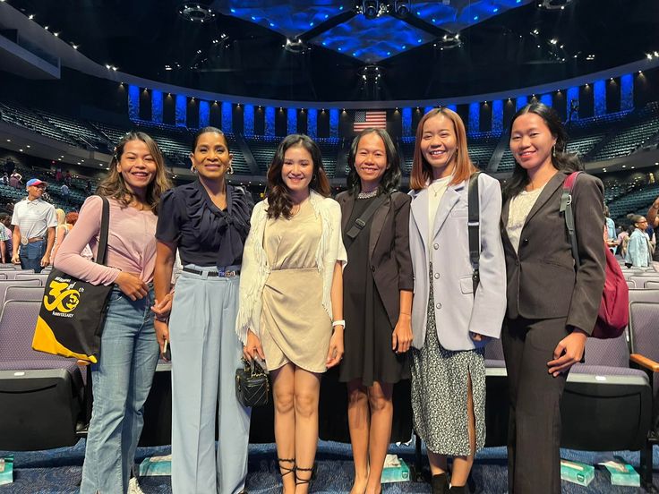 a group of women standing next to each other in front of an audience at a convention