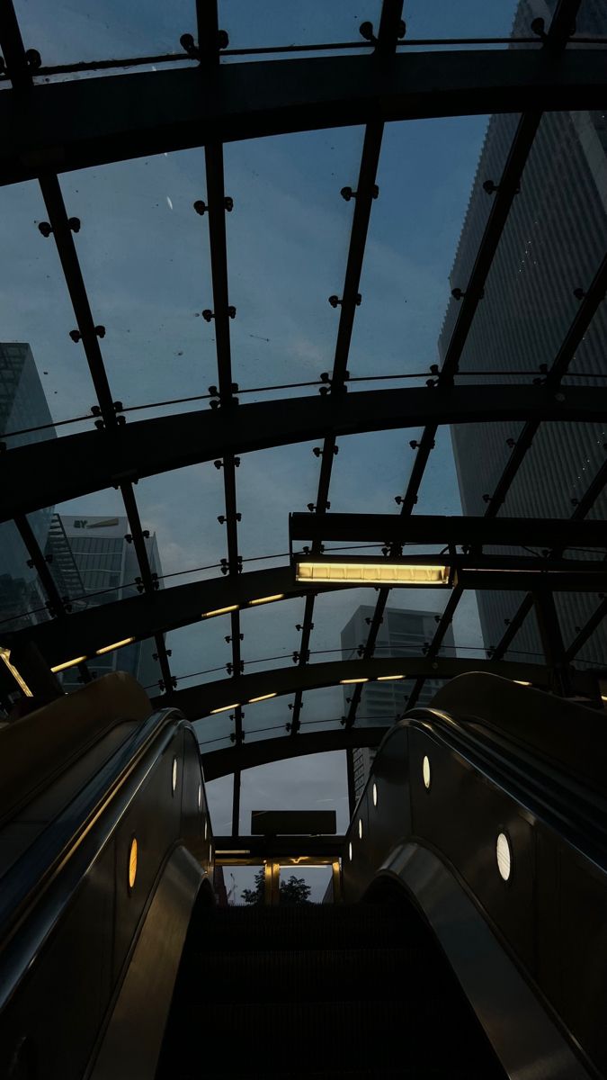 an escalator in a subway station at dusk