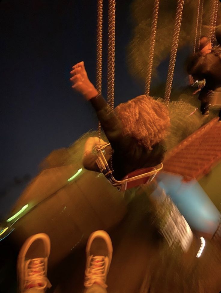 a person swinging on a swing at night