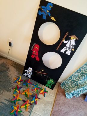 a room with some toys on the floor next to a black board that has stickers all over it