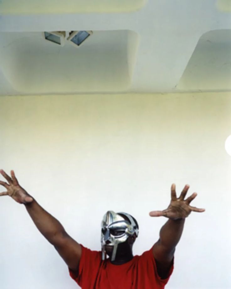 a man wearing a helmet and holding his hands up in the air