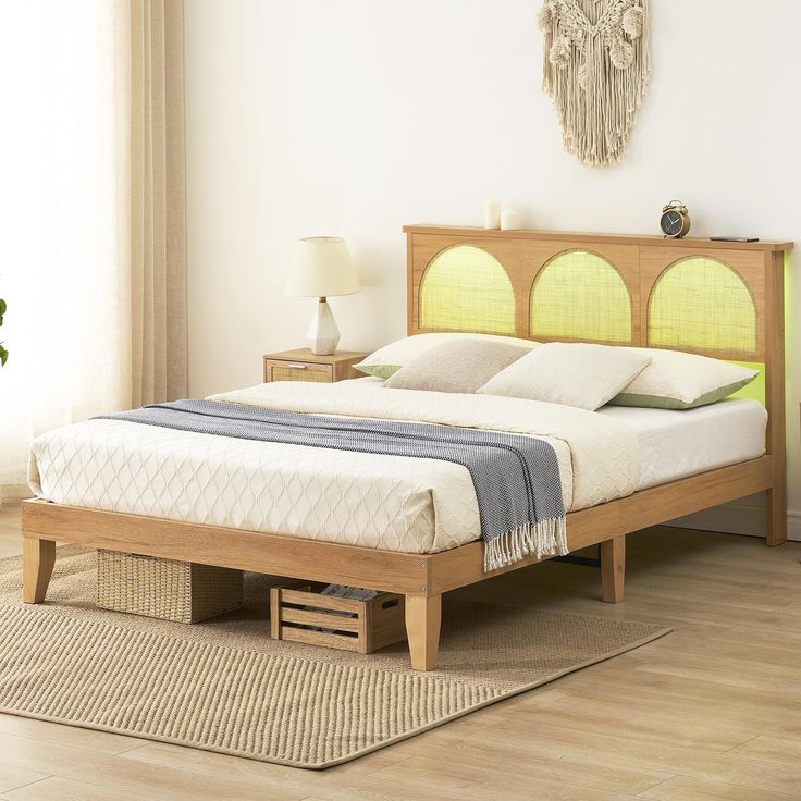 a bed sitting on top of a hard wood floor next to a dresser and lamp