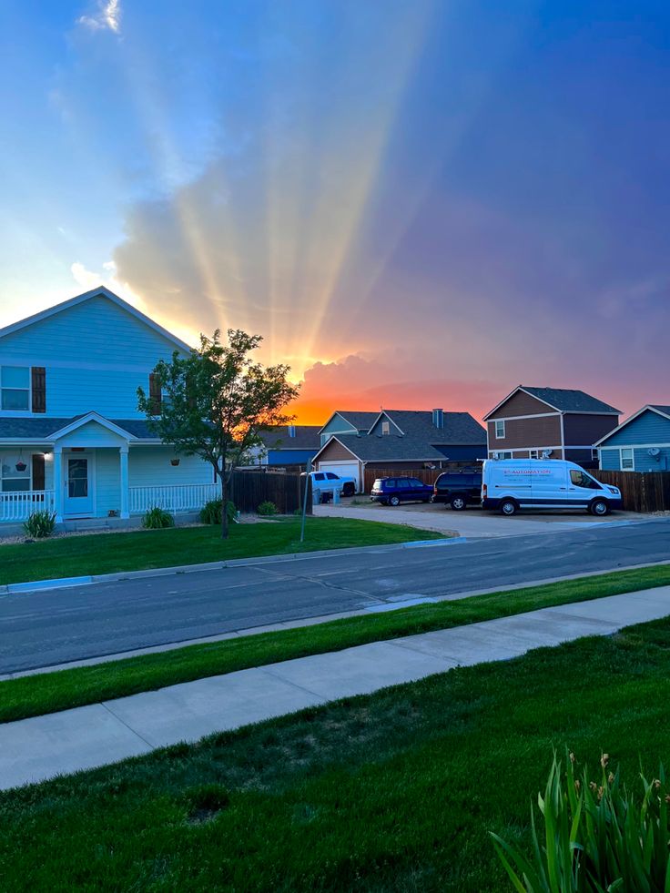 the sun shines brightly over houses on a suburban street at dusk in this residential neighborhood