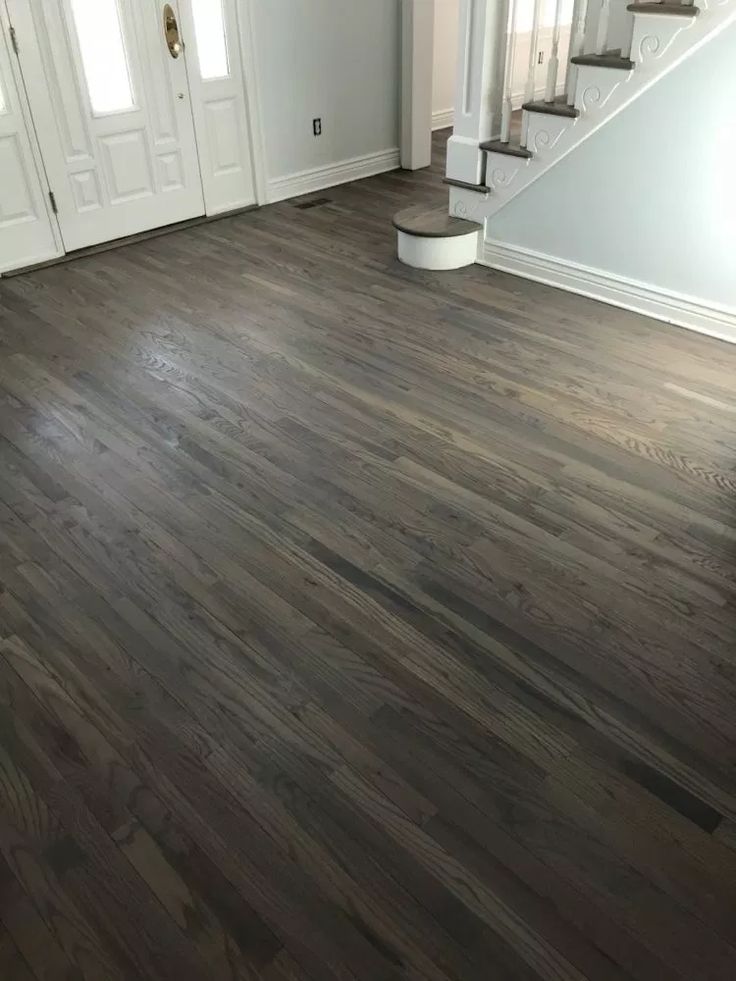 an empty room with wood floors and stairs