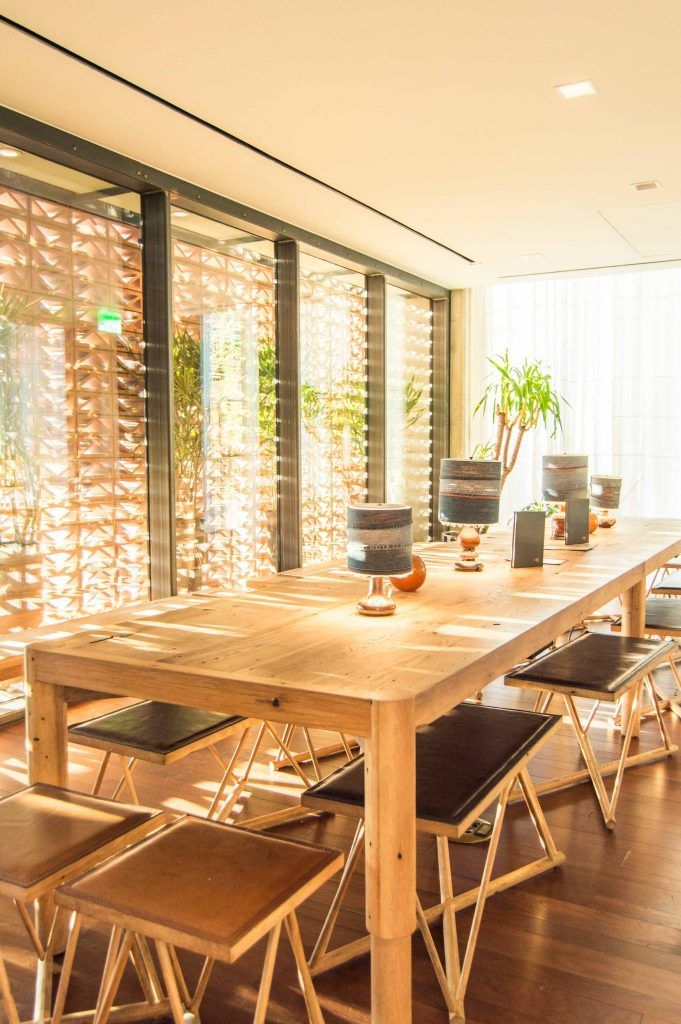 a dining room table with chairs and plants