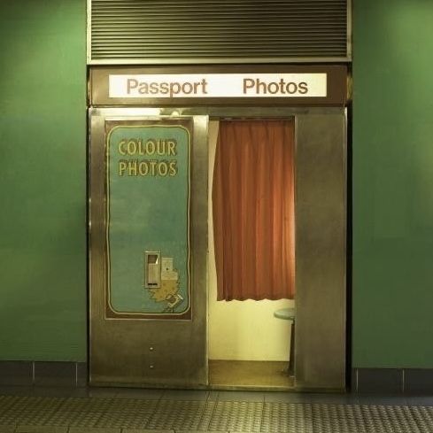 an entrance to a train station with a sign on the door that says passport photos