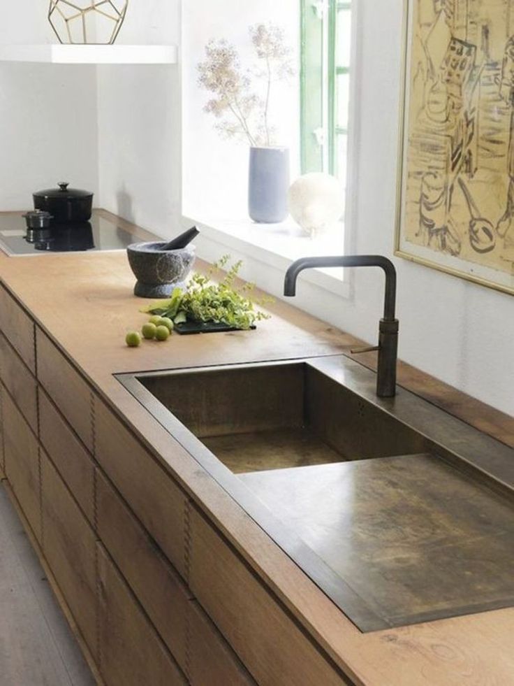 a kitchen with a sink and wooden counter tops in it's center island area