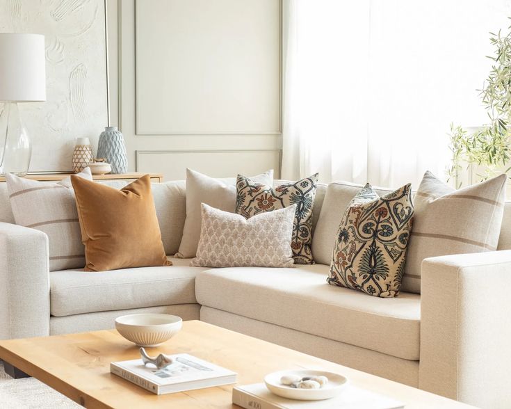 a living room filled with lots of furniture and pillows on top of a wooden table