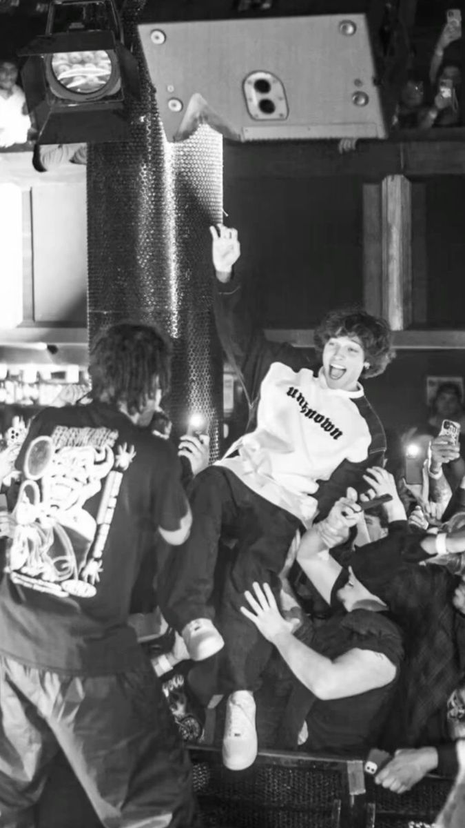 black and white photograph of young men playing with each other in front of a crowd