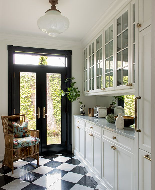 a black and white checkered floor in a kitchen with an open door to the outside