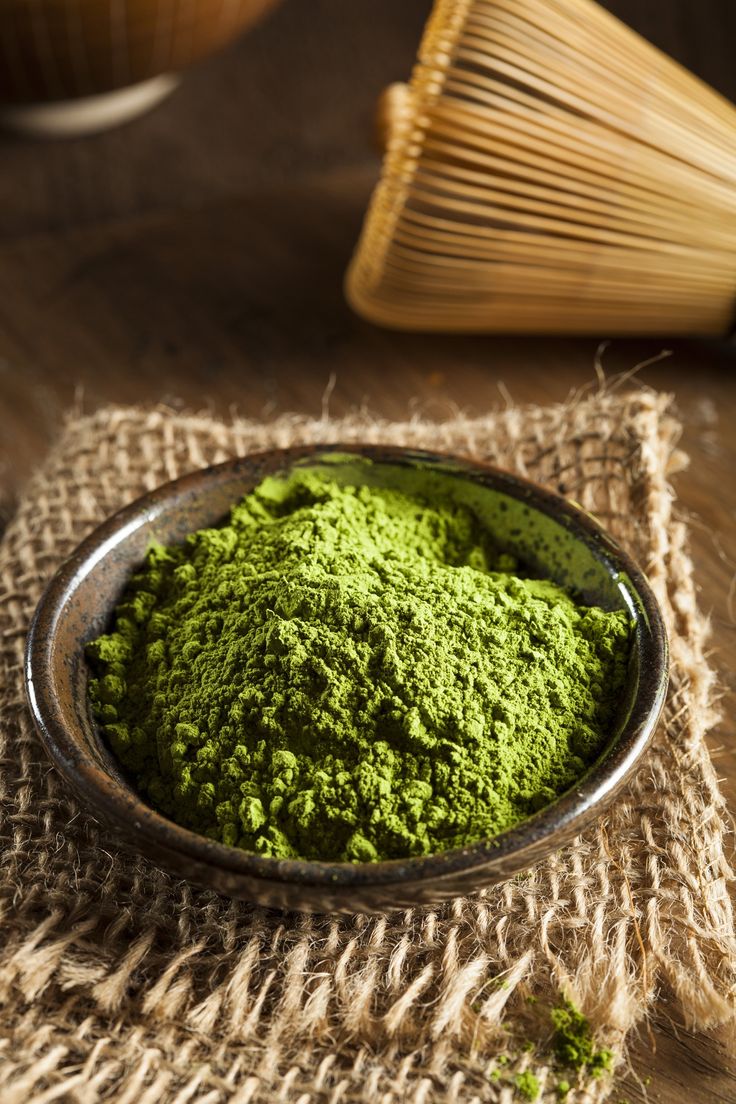 a bowl filled with green powder on top of a table