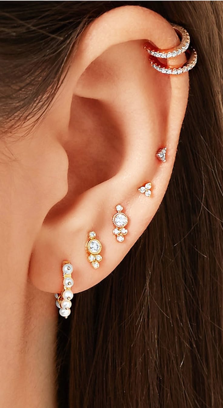 a woman wearing three different types of ear piercings on her left side of the ear