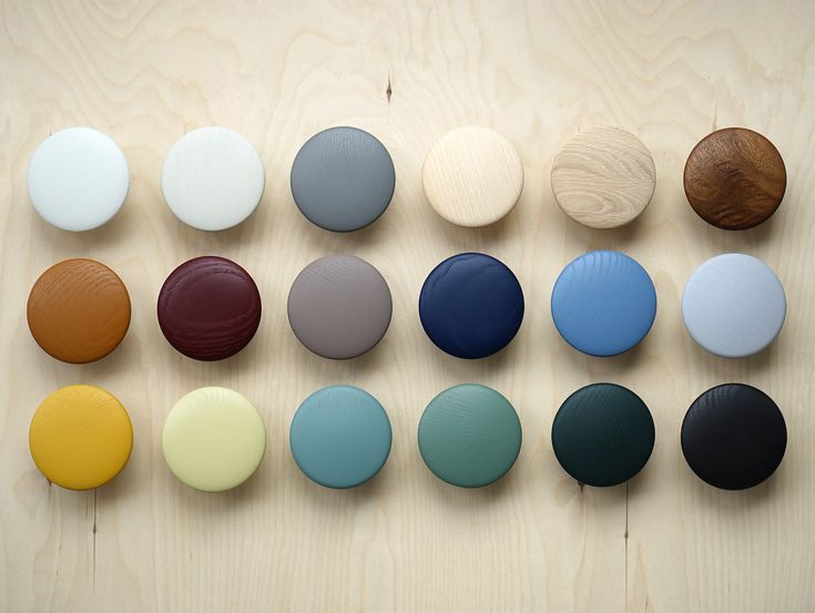 a group of different colored buttons sitting on top of a wooden table next to each other