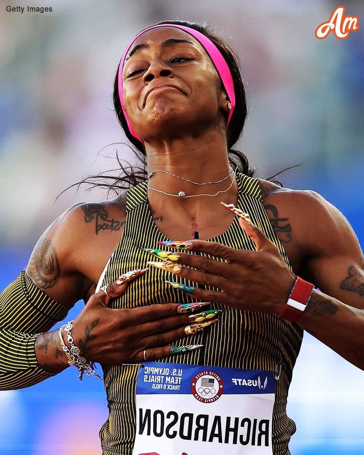 a woman with tattoos on her arm and chest standing in the middle of a race