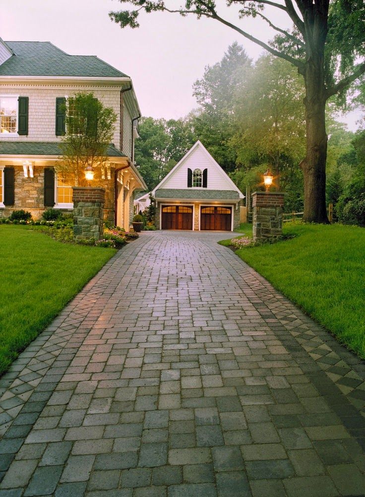 a driveway leading to a large white house