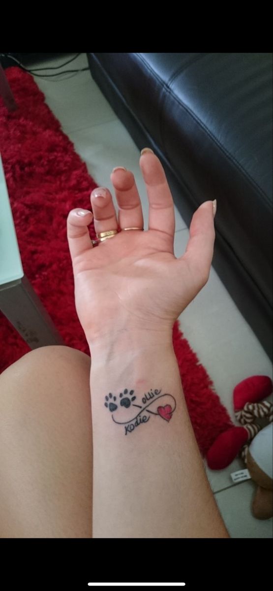 a woman's arm with a tattoo on her left wrist and paw prints on it