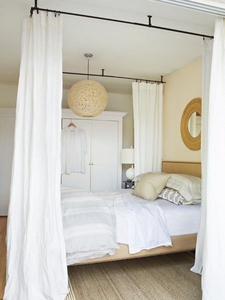 an article in the magazine shows a bed with white sheets and drapes hanging over it