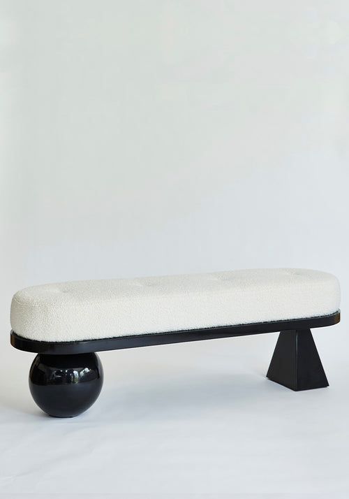 a black and white bench sitting on top of a white floor next to a wall