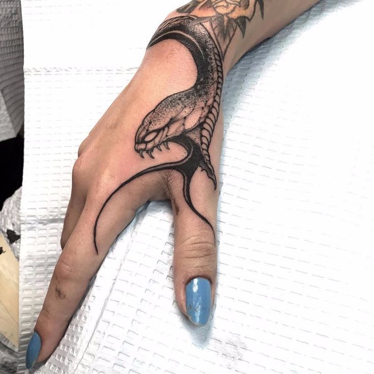 a person's hand with a tattoo on it and an image of a lizard