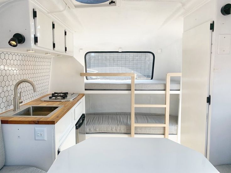 a small kitchen with a bunk bed and sink