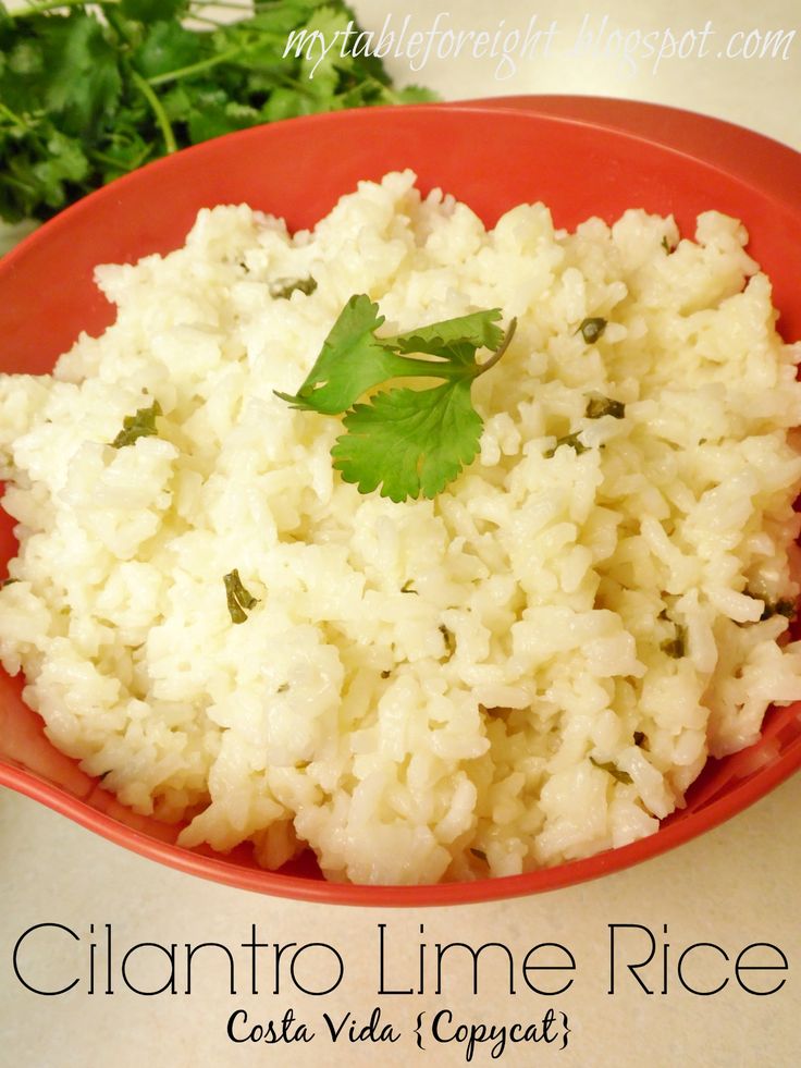 a red bowl filled with rice and garnished with cilantro