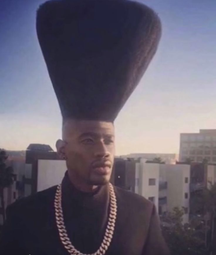 a man with a weird hat on his head standing in front of a cityscape