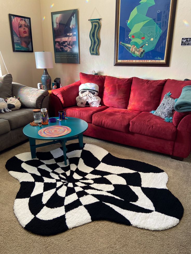 a living room with red couches and black and white rug