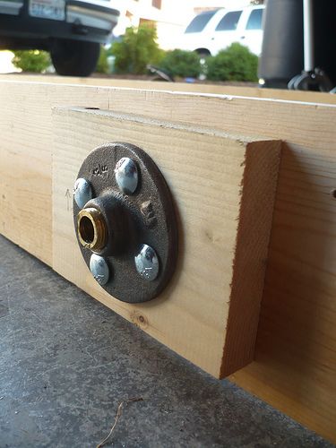 a close up of a piece of wood with screws and nuts attached to it