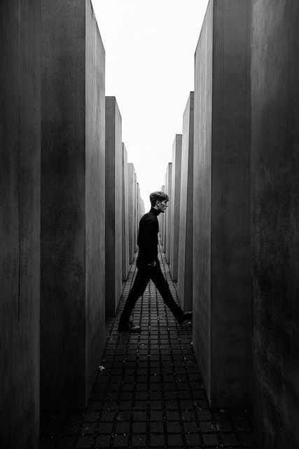 black and white photograph of a man walking through a wall