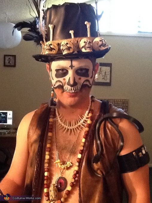 a man wearing a costume with skulls and feathers on his head