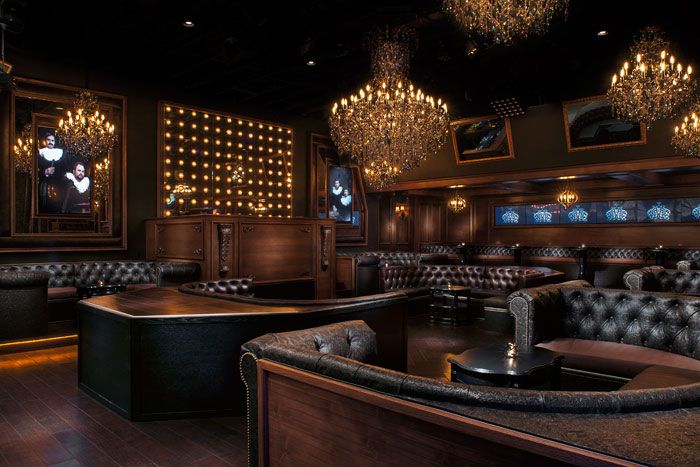 a fancy bar with leather couches and chandeliers