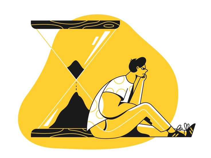 a man sitting on the ground next to an hourglass