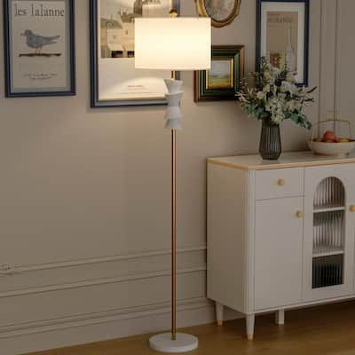 a living room scene with focus on the floor lamp and sideboard cabinet against the wall