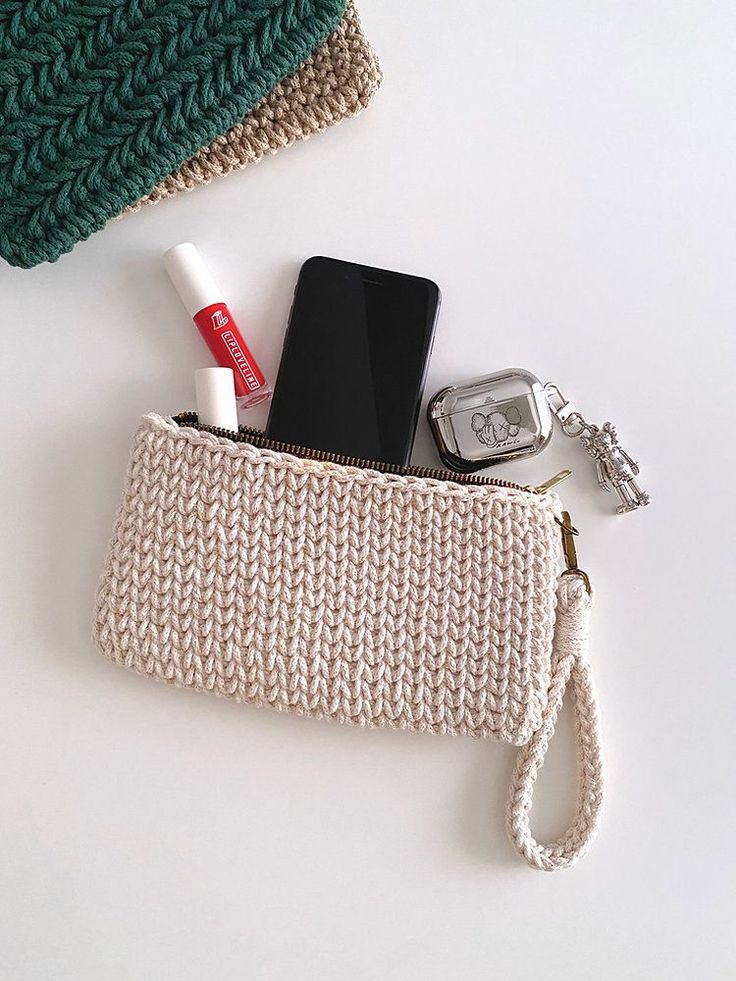 a cell phone and wallet sitting on top of a white table next to a purse