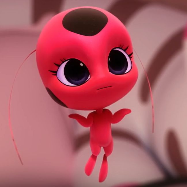 a little red toy with big eyes hanging upside down