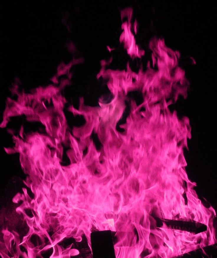 the fire is glowing pink in the dark