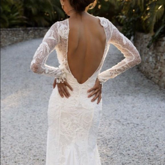 the back of a woman's wedding dress, with her hands on her hips