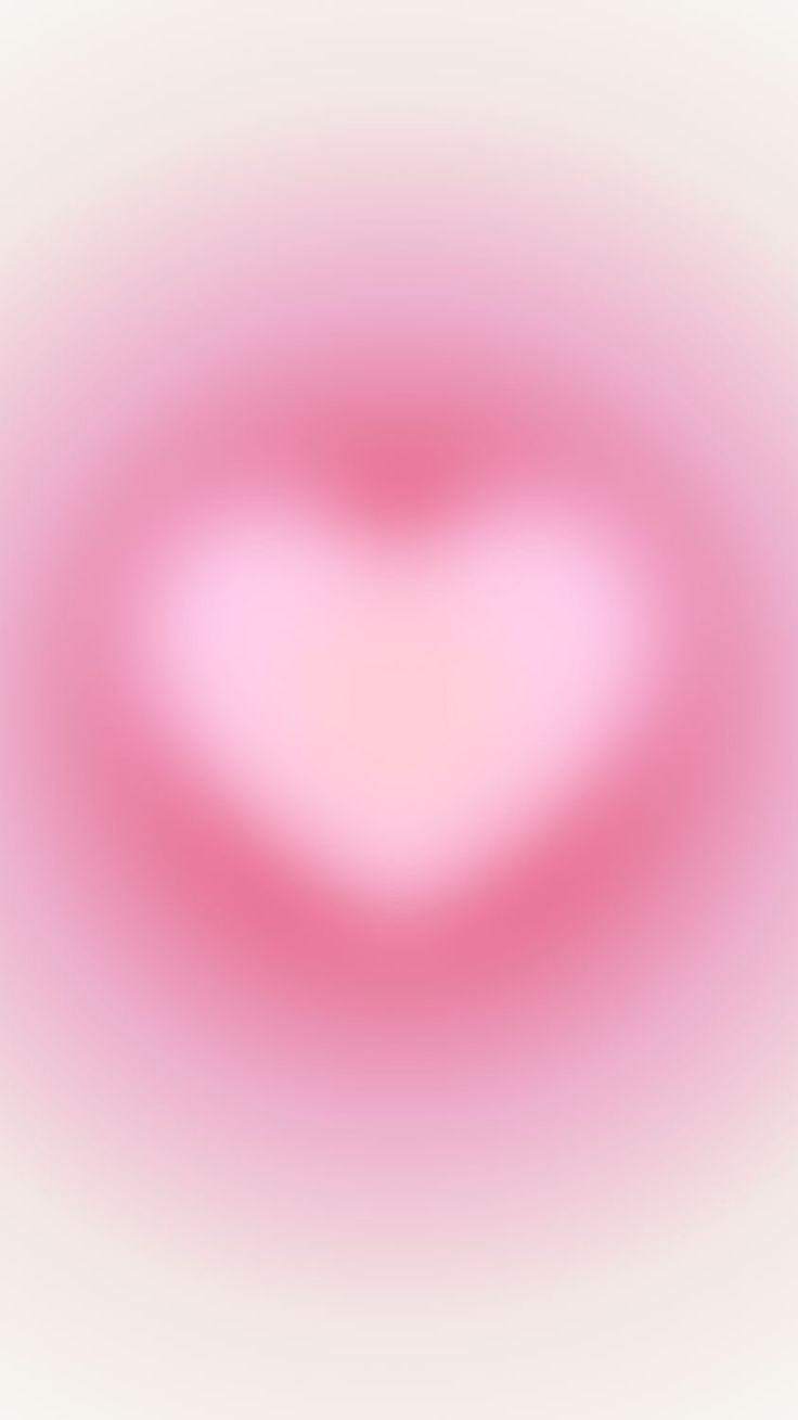 a blurry image of a pink heart in the middle of it's frame