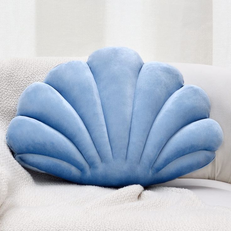 a blue pillow sitting on top of a white couch