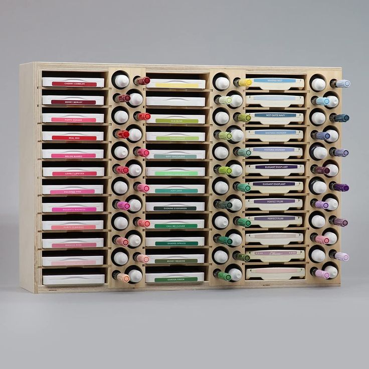 an assortment of pens and pencils in a wooden holder