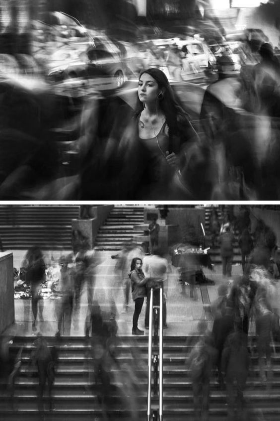 black and white photo of people walking down the street in front of an escalator