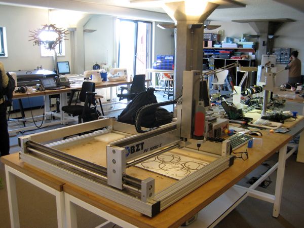 people working in an office with many desks and computers