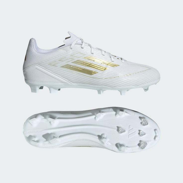 a white soccer shoe with gold detailing on the top and bottom part of the shoe