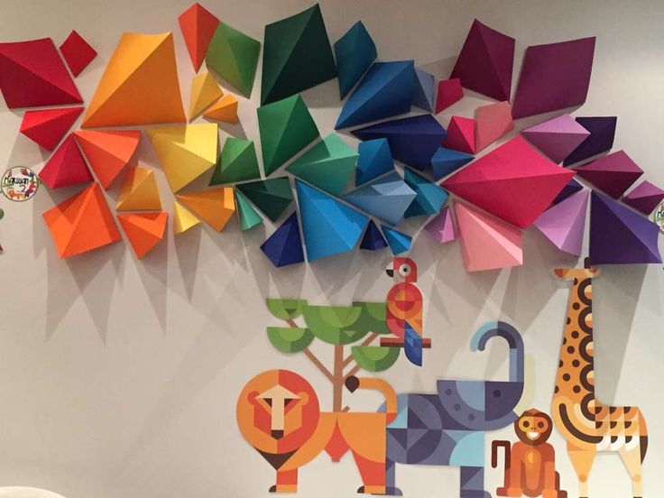 the wall is decorated with colorful origami pieces