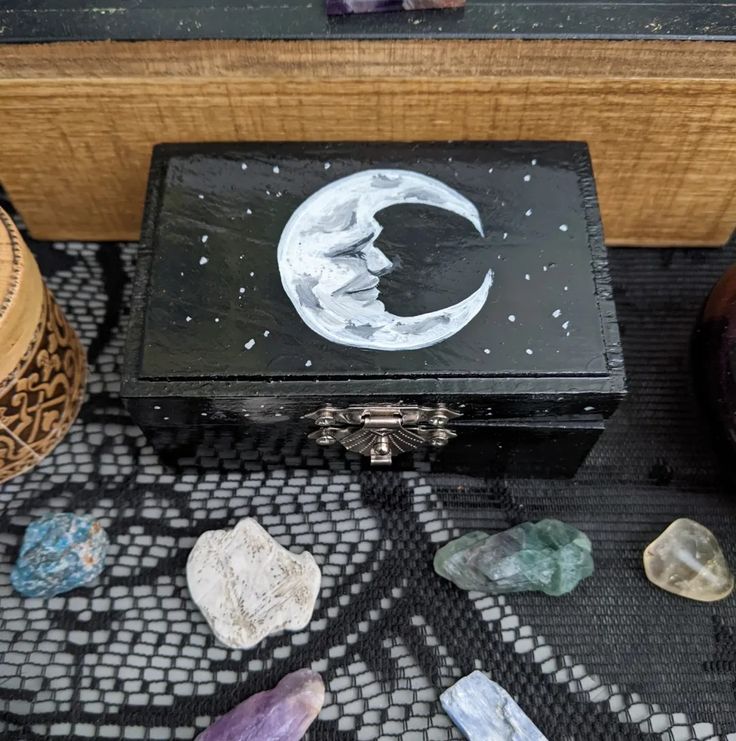 a wooden box sitting on top of a table filled with stones