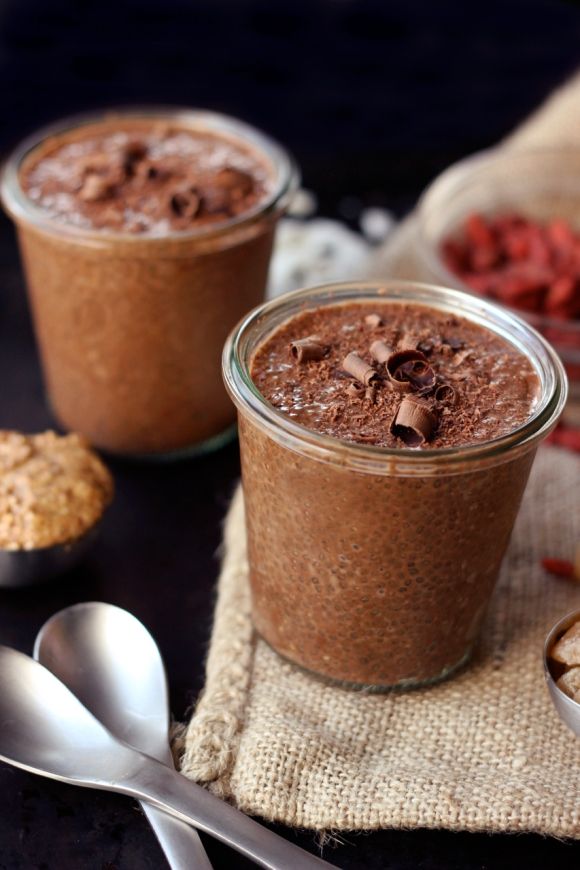 a glass jar filled with chocolate pudding next to a bowl of marshmallows