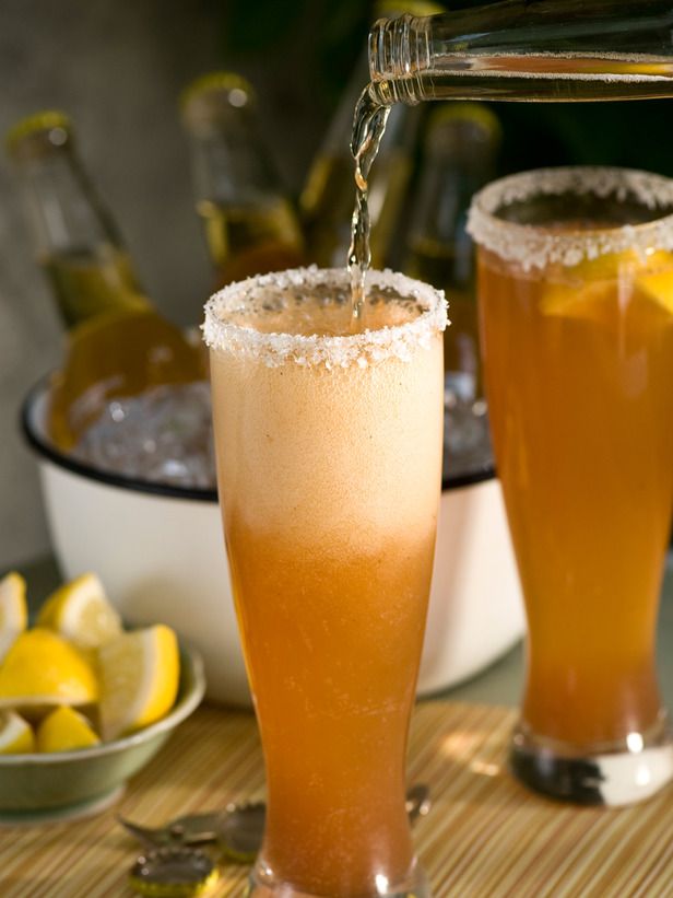 two glasses filled with drinks sitting on top of a table